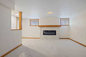 Unfurnished living room featuring carpet flooring and a high end fireplace