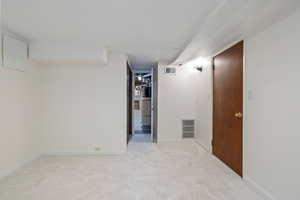 Spare room featuring light colored carpet and baseboards