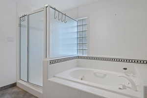 Bathroom featuring a stall shower and a bath