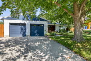View of front of home featuring driveway, an attached garage, and brick siding