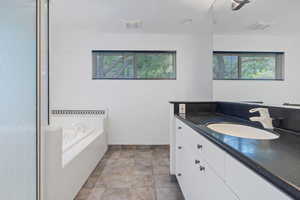 Bathroom with vanity, plenty of natural light, and a bath