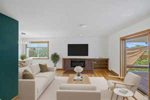 Living area with wood finished floors and a glass covered fireplace