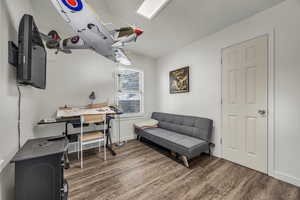 Office with dark wood-style flooring and baseboards