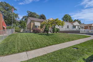 View of front of home with a fenced front yard and brick siding