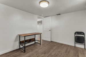 Home office featuring a textured ceiling and dark wood finished floors