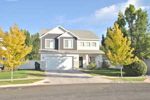 Craftsman house featuring concrete driveway, a garage, covered porch, board and batten siding, and roof with shingles