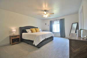Carpeted bedroom featuring baseboards and a ceiling fan