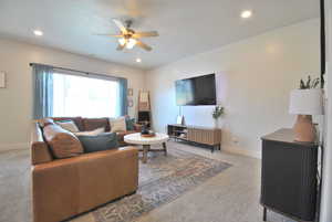 Living room with light carpet, a ceiling fan, and recessed lighting
