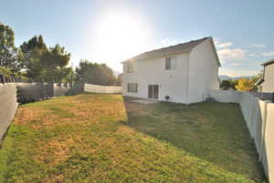 Rear view of house featuring a patio area and a fenced backyard