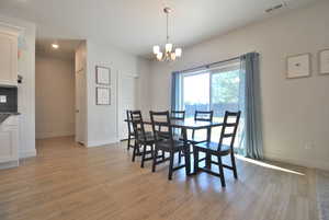 Dining space featuring light wood-type flooring, a chandelier, and recessed lighting