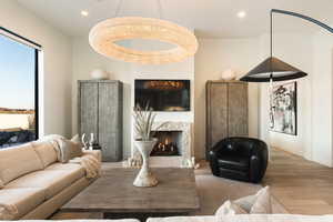 Living area with wood finished floors, a fireplace, and recessed lighting