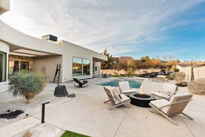 View of swimming pool with a patio area and a fire pit