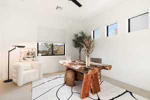 Carpeted dining room featuring plenty of natural light and a ceiling fan