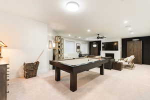 Rec room featuring billiards table, light colored carpet, a fireplace, recessed lighting, and ceiling fan