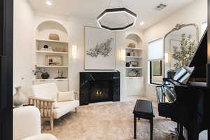 Living area with built in features, a fireplace, and recessed lighting