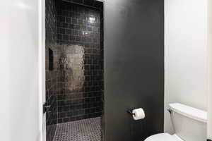 Full bath with toilet and a stall shower