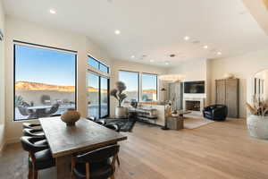Dining area featuring recessed lighting, light wood-type flooring, a premium fireplace, and arched walkways