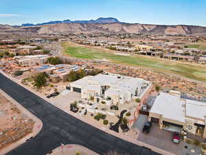 Aerial view of residential area featuring a mountain backdrop and a golf course