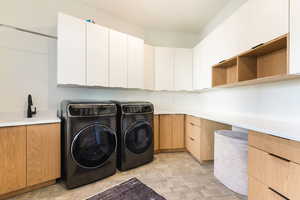 Laundry room featuring cabinet space and washing machine and clothes dryer