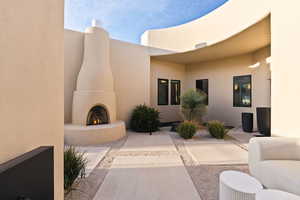View of patio / terrace featuring a warm lit fireplace