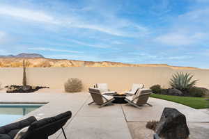 Fenced backyard with a mountain view, a patio area, and an outdoor fire pit