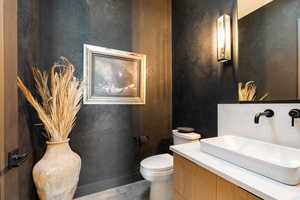 Half bathroom featuring vanity and toilet