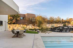 View of swimming pool with a patio area and outdoor dining space