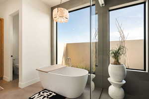 Bathroom featuring healthy amount of natural light and a soaking tub