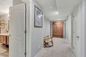 Hallway featuring light colored carpet and recessed lighting