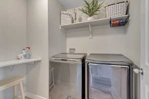 Laundry area featuring washing machine and dryer and baseboards