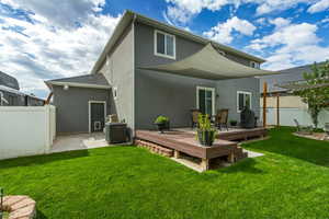Back of property with stucco siding, a patio area, and a wooden deck