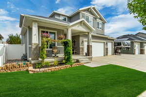 Craftsman inspired home featuring stucco siding, covered porch, stone siding, concrete driveway, and an attached garage