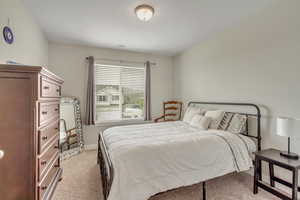 Bedroom with light colored carpet and baseboards