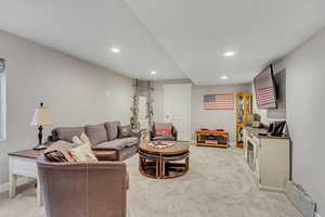 Living area with light colored carpet and recessed lighting