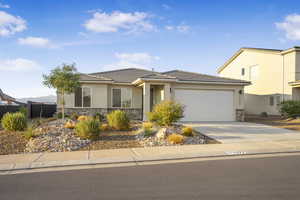 View of front of house featuring stone siding, stucco siding, driveway, and a garage