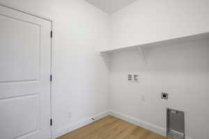 Laundry area featuring light wood finished floors, washer hookup, and electric dryer hookup