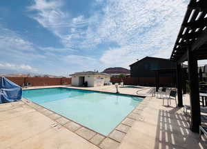 Community pool with a pergola, a patio area, and area for grilling