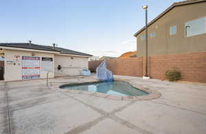 Outdoor pool with a fenced backyard and a patio area