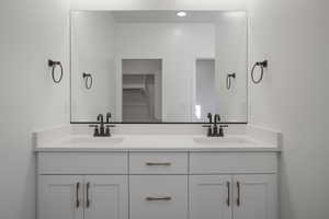 Bathroom with double vanity and a spacious closet