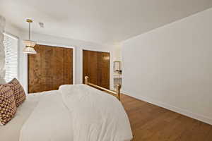 Bedroom with wood finished floors and multiple closets