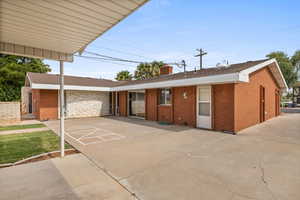 View of front of home featuring brick siding, a chimney, and a shingled roof