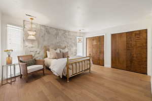 Bedroom featuring multiple closets and light wood finished floors