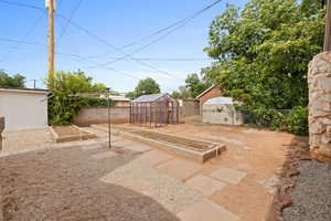 View of patio / terrace featuring a garden, an outdoor structure, and a greenhouse