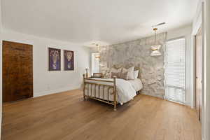 Bedroom with hardwood / wood-style flooring and baseboards