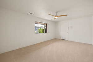 Unfurnished room featuring light colored carpet and a ceiling fan