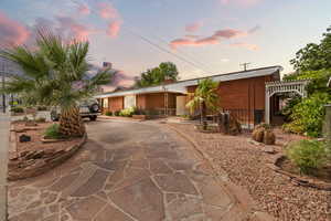 View of front of house with brick siding, driveway, and a chimney