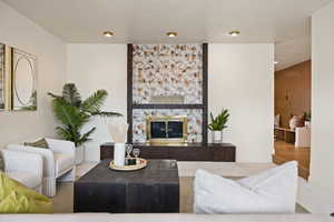 Living area with a stone fireplace and baseboards