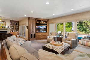 Carpeted living room featuring a fireplace, recessed lighting, and a textured ceiling