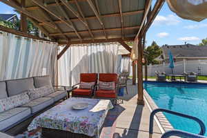 View of swimming pool featuring outdoor lounge area, a fenced backyard.