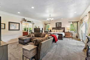 Carpeted bedroom featuring crown molding, a textured ceiling, access to outside, a chandelier, and recessed lighting